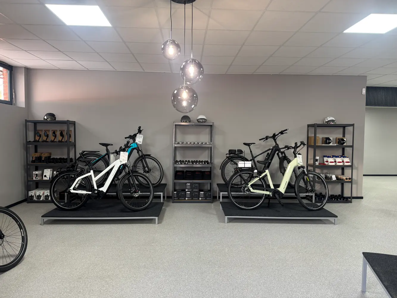 Zwei helle und moderne Elektrofahrräder stehen ausgestellt in einem stilvollen Showroom