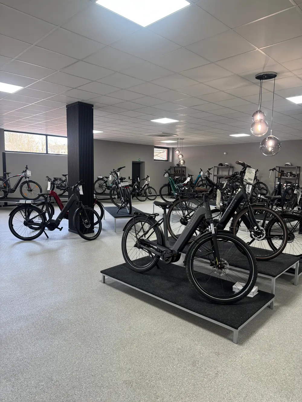 In einem modernen Fahrradladen stehen verschiedene E-Bikes auf Podesten ausgestellt